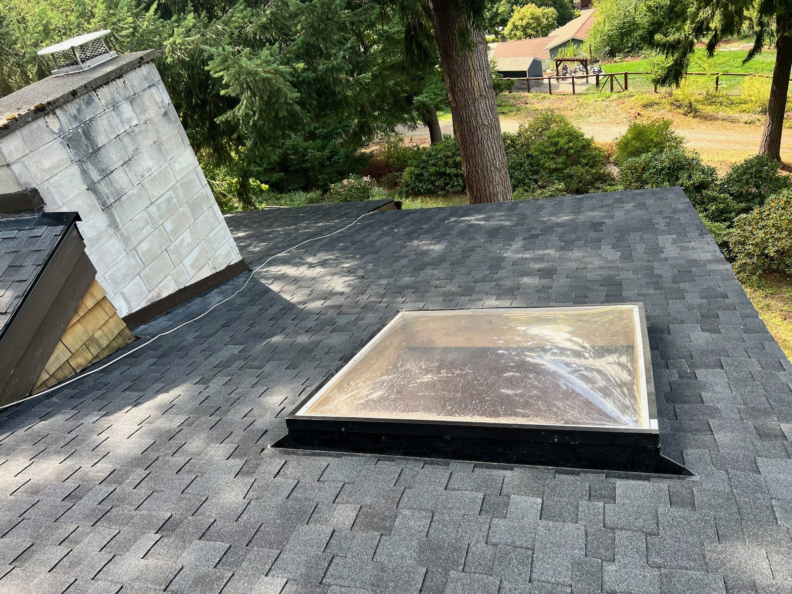 New architectural shingles around a skylight and chimney
